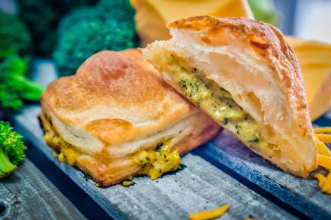 A flaky savory mini puff pastry pie cut open to show its filling