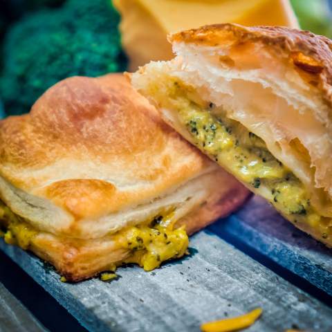 A generously filled croissant sandwich on a bakery board