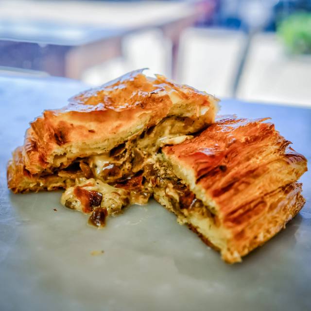 A savory mini puff pastry pie with a crisp laminated crust